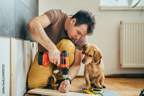 Man and his dog doing renovation work at home photo