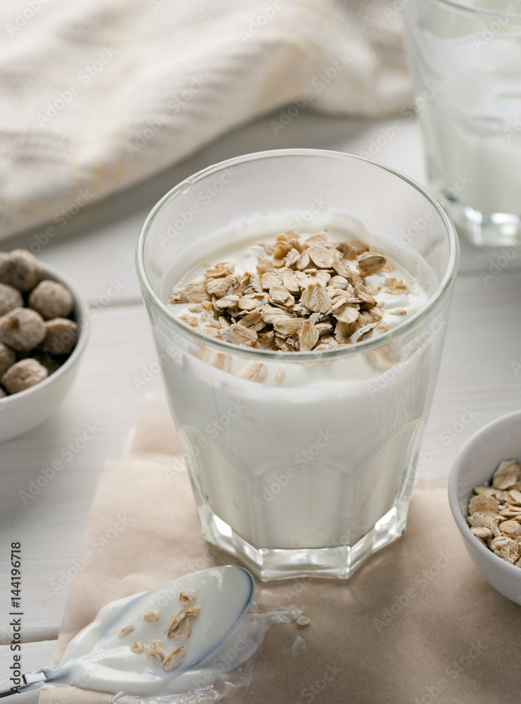 Yogurt with cereal on a white table, vertical Yogurt with cereal on a white table, vertical
