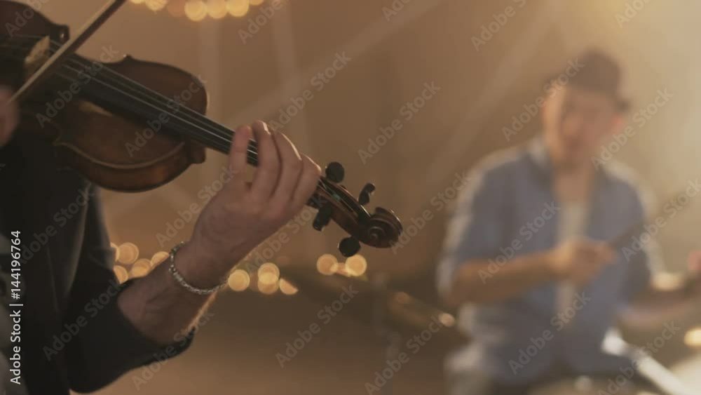 Man Playing a Violin, Young Percussionist in the Background Man Playing a Violin, Young Percussionist in the Background