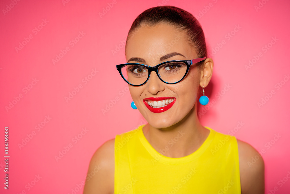 Beautiful smiling woman in glasses over pink background