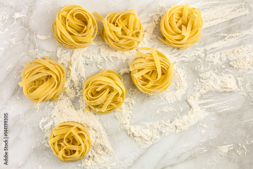Overhead photo of pasta nests on white marble
