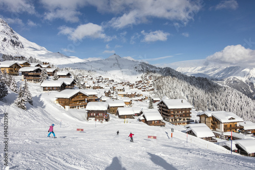 Skiers on the ski slopes frame the typical alpine village Bettmeralp district of Raron canton of Valais Switzerland Europe photo