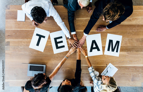 Foto Team word on table with business people stacking hands