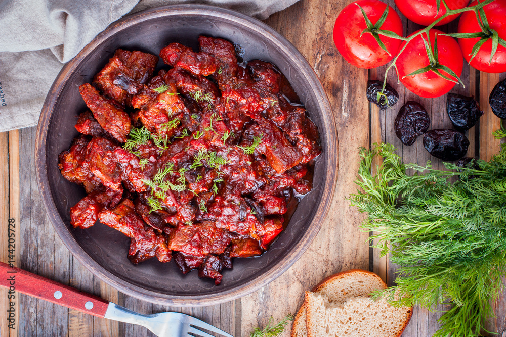 Beef with tomatoes and prunes, top view, horizontal Beef with tomatoes and prunes, top view, horizontal