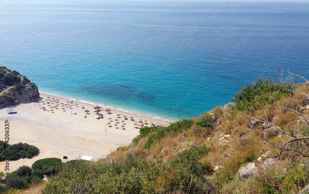 Summer Albania beach view. Ionian and Adriatic sea. Seashore with wave sand rock stone sky and sun. Pleasant travel recreation