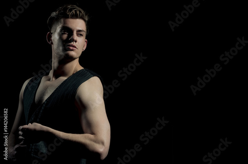 Handsome man unbuttoning vest with muscular hands
