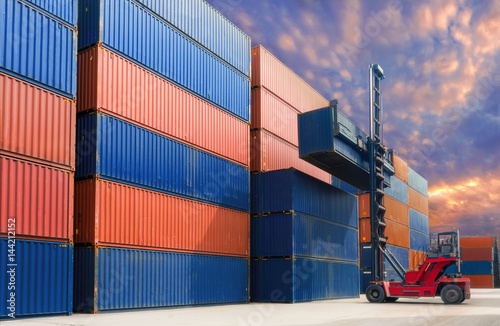 Forklift handling container in yard.