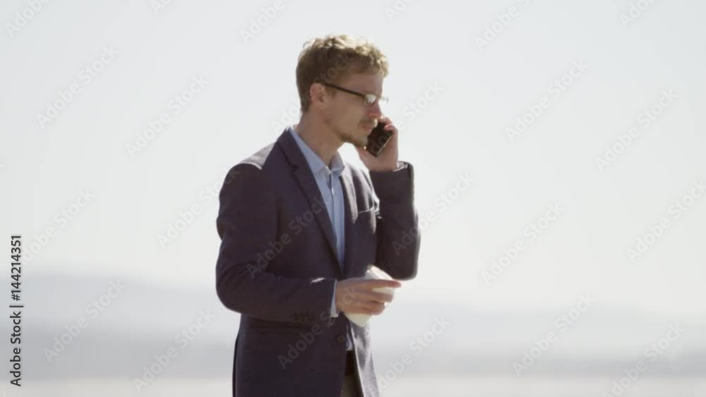 Young businessman walking along the Pacific ocean coast