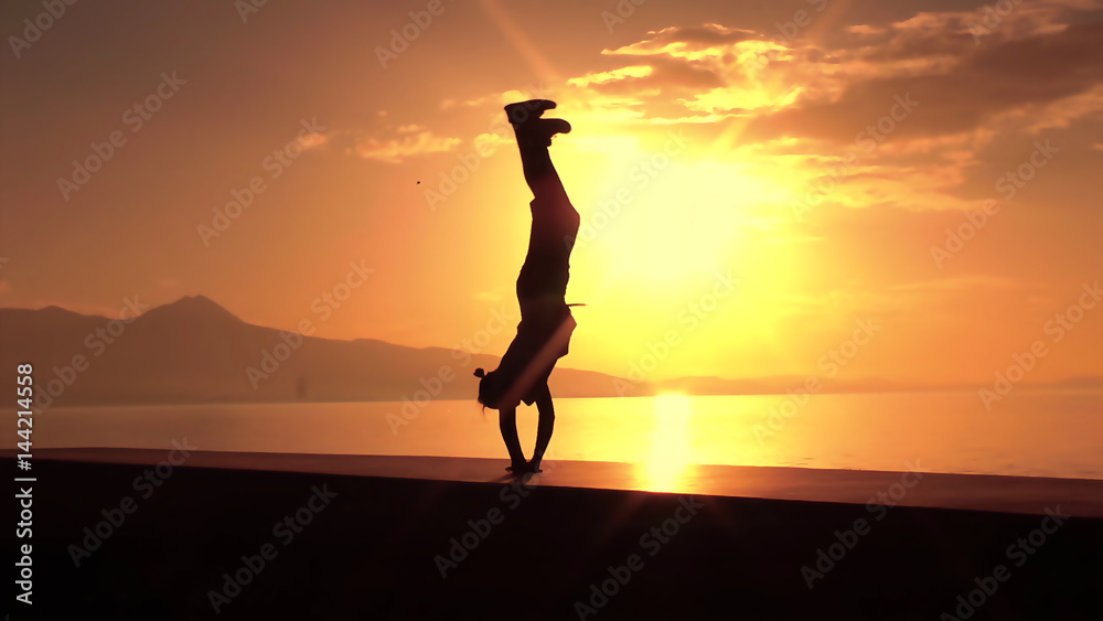 silhouette of acrobat at sunset