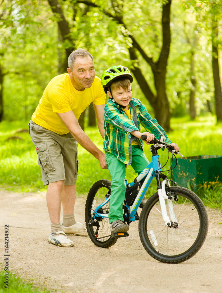 Obraz premium Father teaching his son to ride a bike