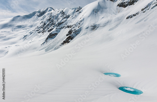 two incredible water ponds,supraglacial lakes, over the snow at Forni glacier with S.Matteo peak in the back photo