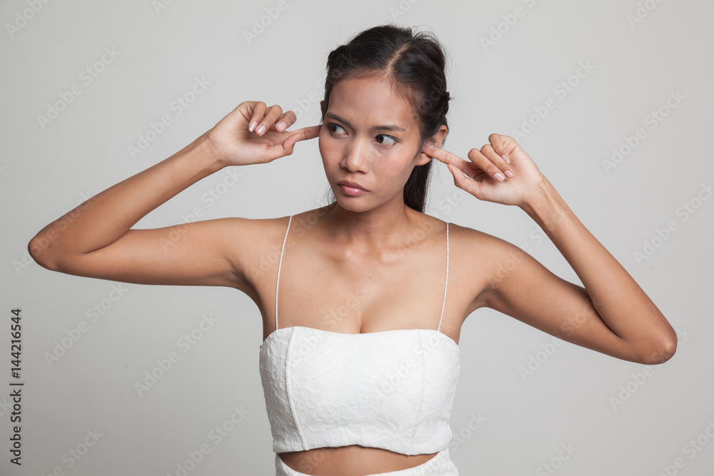 Young Asian woman block both ears with fingers. Young Asian woman block both ears with fingers.