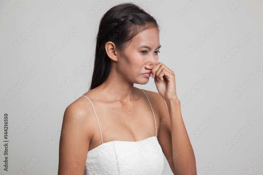 Young Asian woman holding her nose because of a bad smell. Young Asian woman holding her nose because of a bad smell.