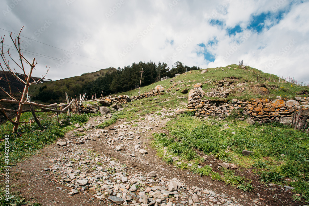 Obraz premium Stepantsminda Gergeti, Georgia. Road To Local Cemetery On The Hi
