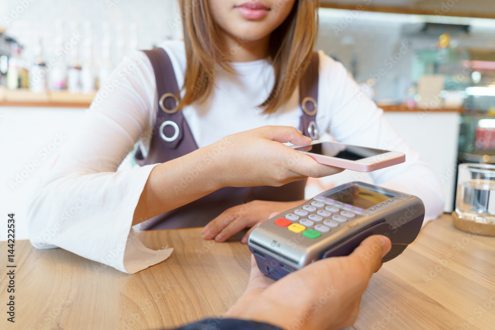Woman paying money via smartphone with magnetic card concept. Woman paying money via smartphone with magnetic card concept.