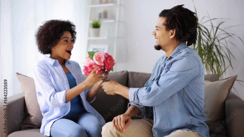 happy couple with bunch of flowers at home happy couple with bunch of flowers at home