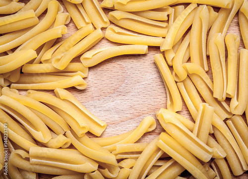 Italian casarecce pasta, wooden background
