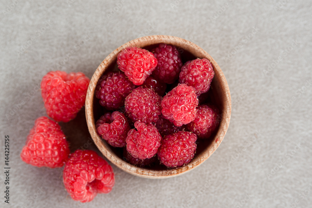 Fresh summer raspberry in a wooden bowl. Top view. Fresh summer raspberry in a wooden bowl. Top view.