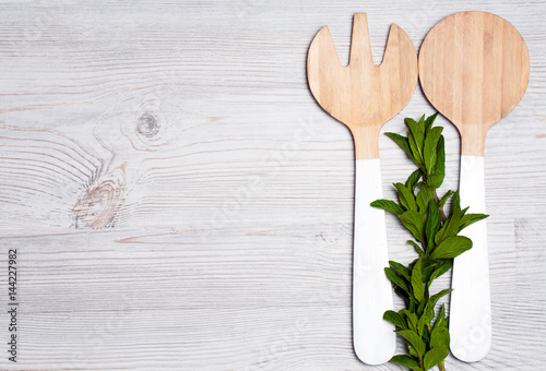 mint leaves with wooden cutlery on white wooden background photo