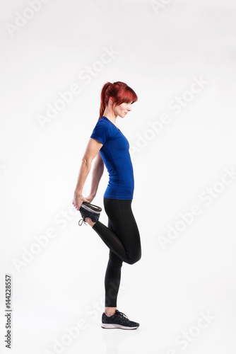 Attractive young fitness woman in blue t-shirt. Studio shot.