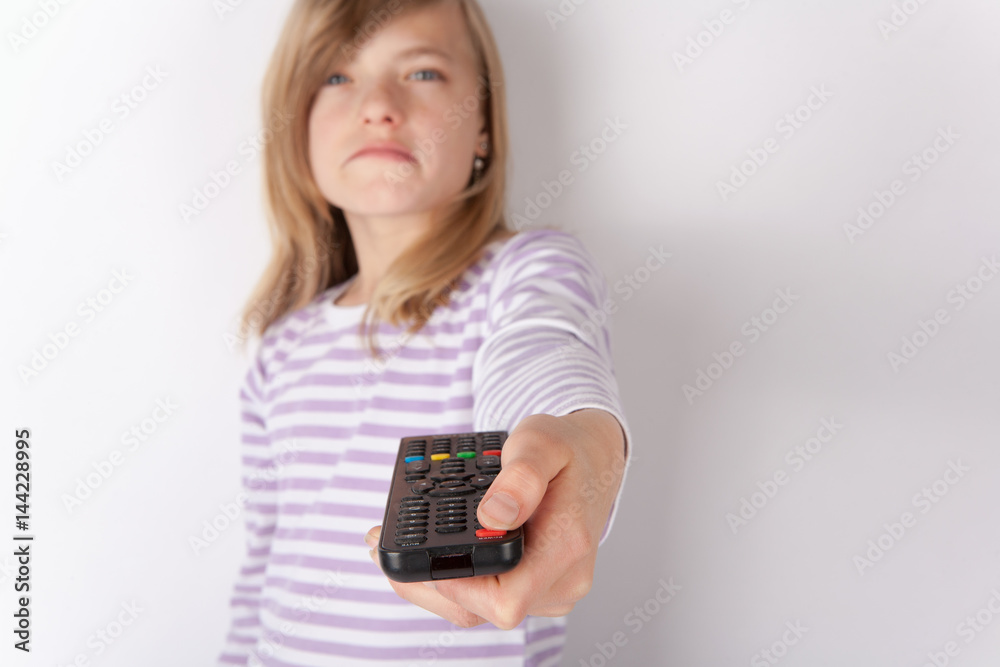Upset girl using remote control switching off the TV