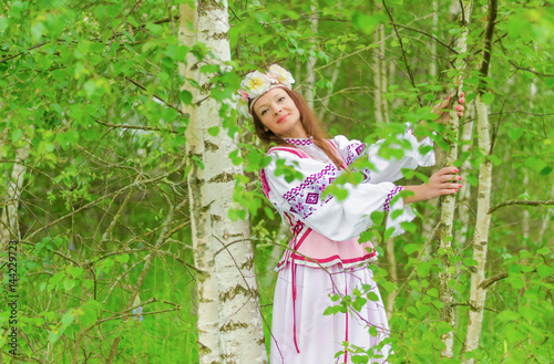 A beautiful girl in a national Belarusian costume against the backdrop of beautiful nature.