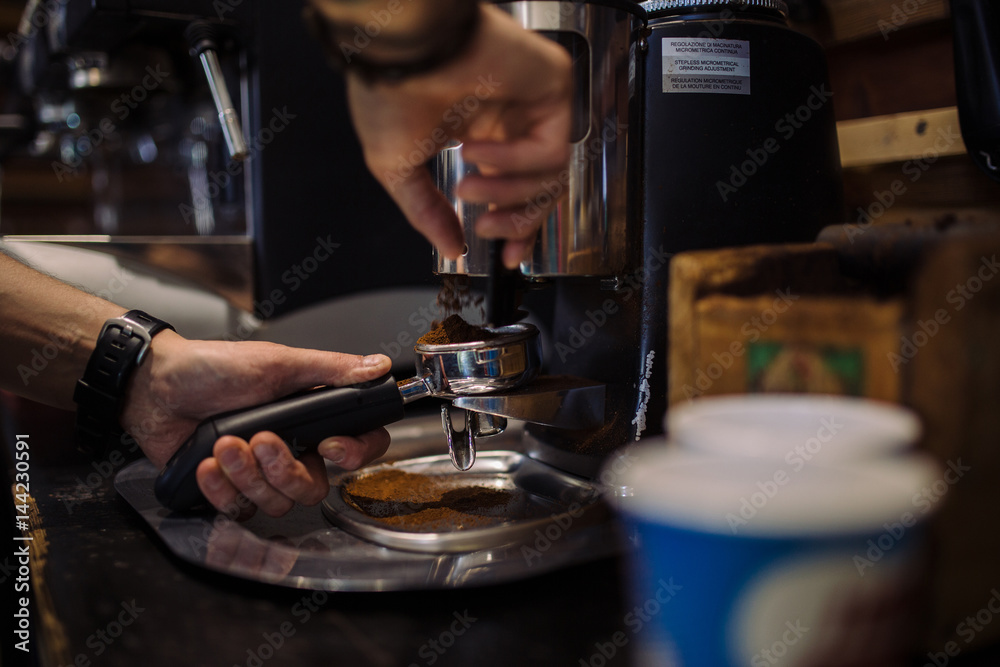coffee grinder in the coffee shop. Barista grinding fresh coffee into bayonet