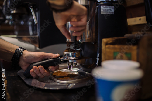 coffee grinder in the coffee shop. Barista grinding fresh coffee into bayonet