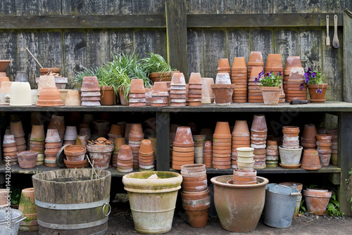 Collection of terracotta pots stacked neatly in the garden.