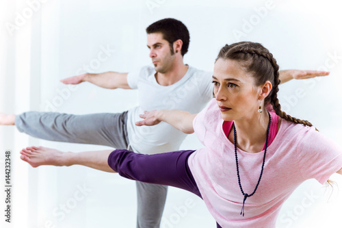 Beautiful young couple practicing yoga at home.