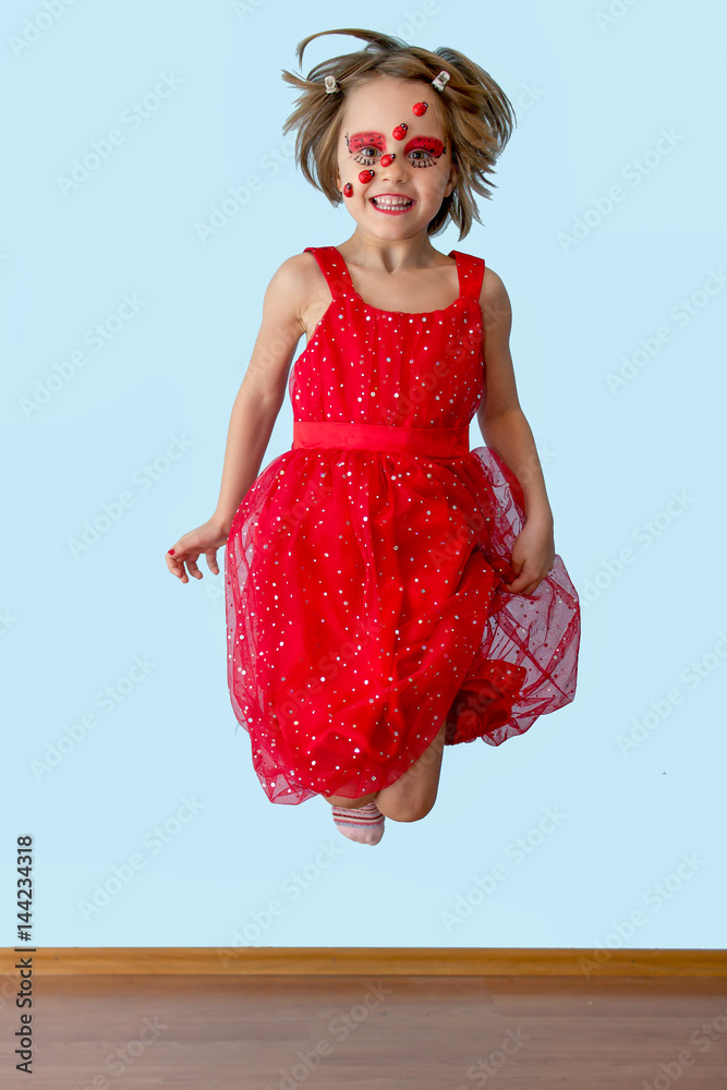 Naklejka premium Little girl with ladybug face paint jumping