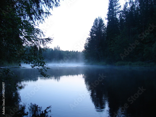 Foggy morning on the river. The fog creeps over the surface of the water. River Chirko-Kem, Karelia, Russia.