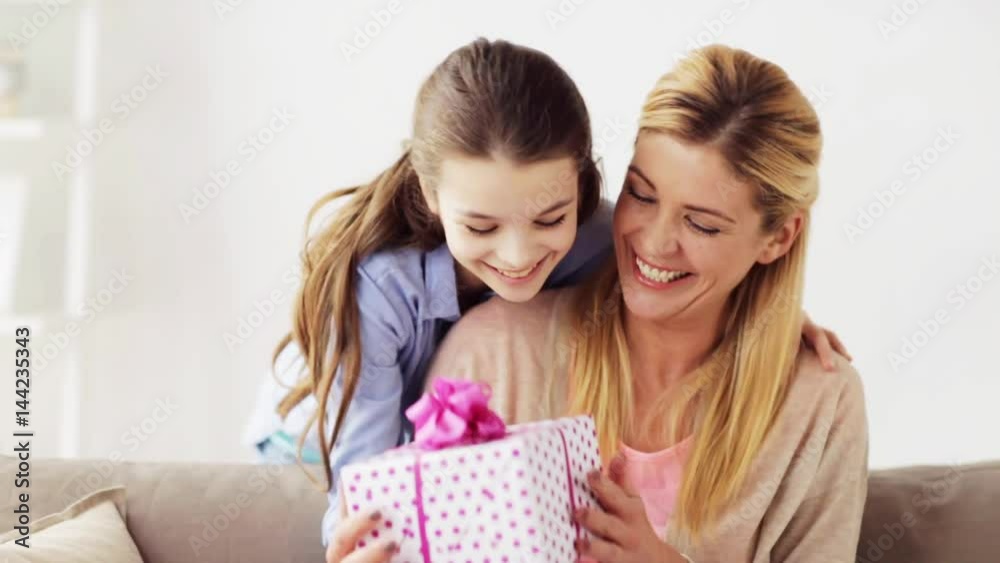 happy girl giving present to mother at home happy girl giving present to mother at home