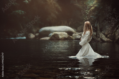 Beautiful woman in mystical stream photo