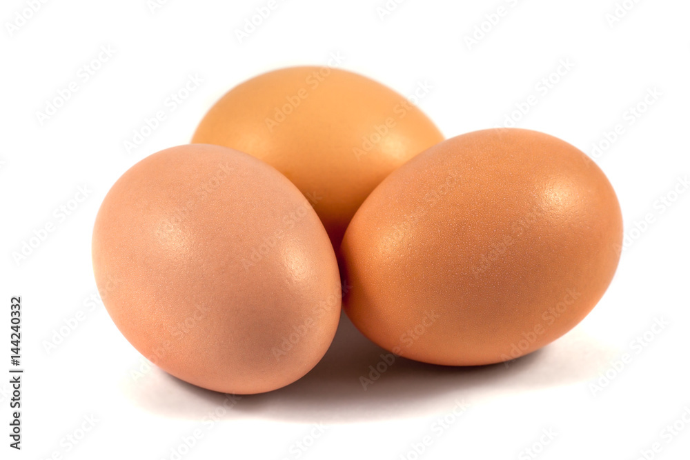 Three brown chicken eggs isolated on white