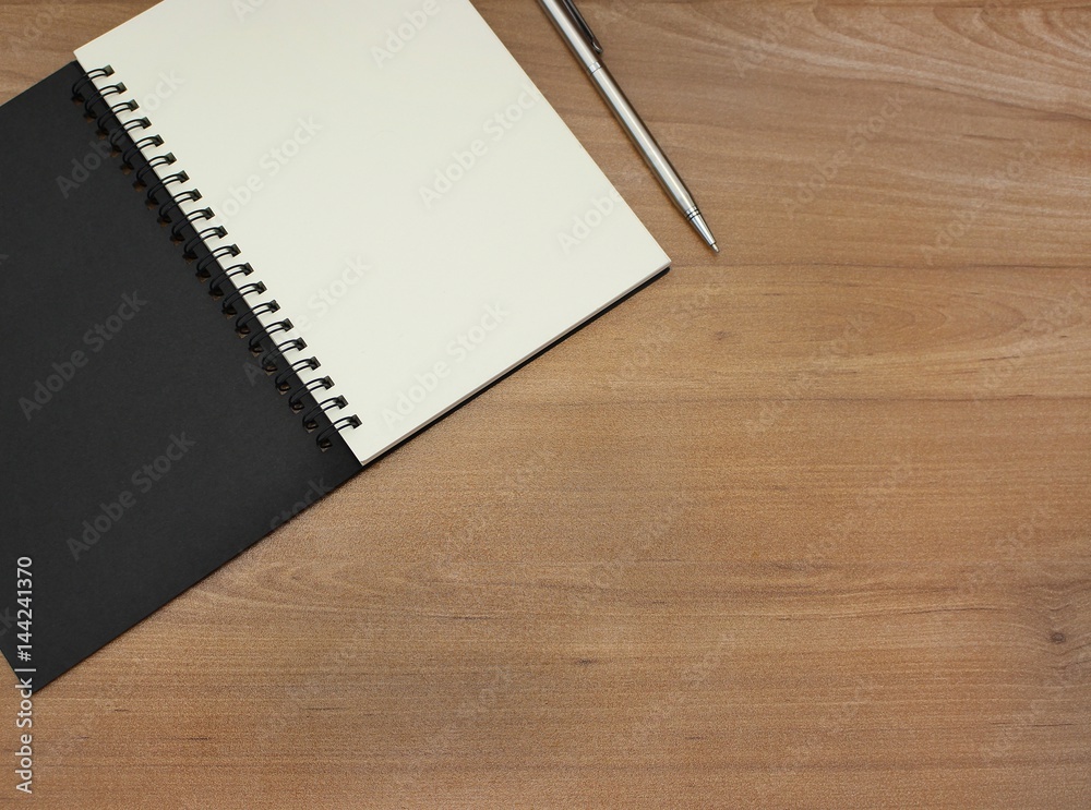 Notebook with white pages and pen on wooden table. Notebook with white pages and pen on wooden table.