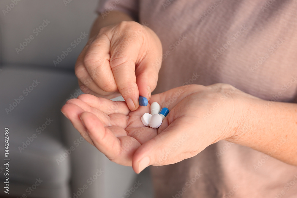 Hands of senior woman with pills, closeup