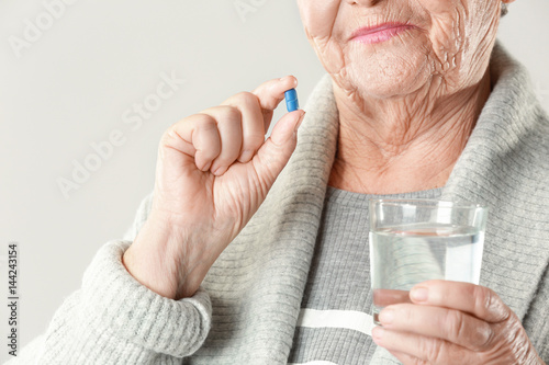 Elderly woman with pill and...