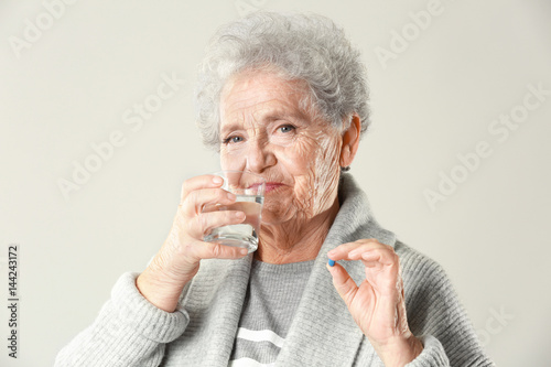 Elderly woman taking pill o...