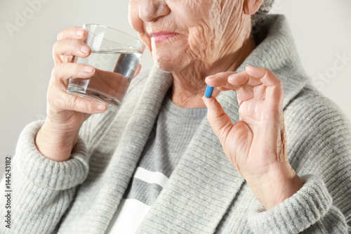 Elderly woman taking pill o...