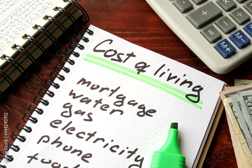 Cost of living written in a notebook and calculations of home finances.