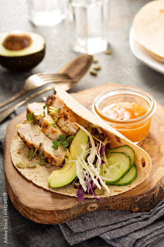 Making tacos with grilled chicken and avocado