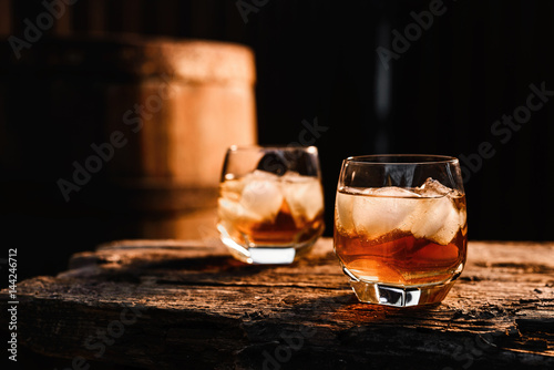 Glass of whiskey on wooden background close up