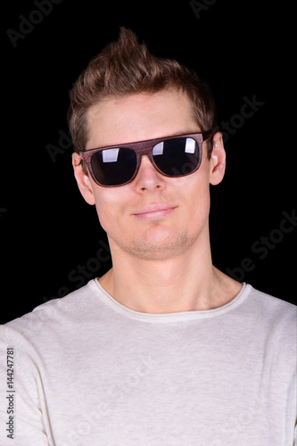 European Young Man in sun glasses isolated on black background