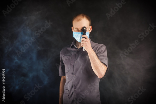young doctor in a mask in smoke