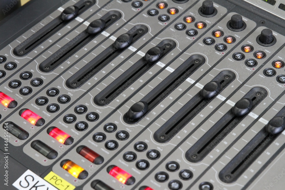 Professional audio operator working on audio mixer knobs during live TV telecast Professional audio operator working on audio mixer knobs during live TV telecast