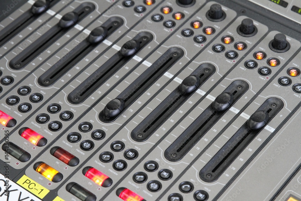 Professional audio operator working on audio mixer knobs during live TV telecast Professional audio operator working on audio mixer knobs during live TV telecast