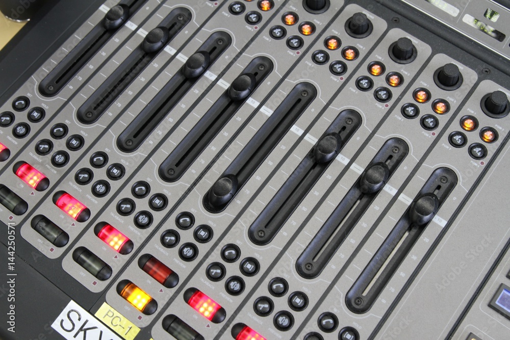Professional audio operator working on audio mixer knobs during live TV telecast Professional audio operator working on audio mixer knobs during live TV telecast