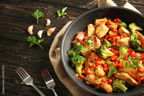 Fototapeta Chicken stir fry with cutlery and spices on table