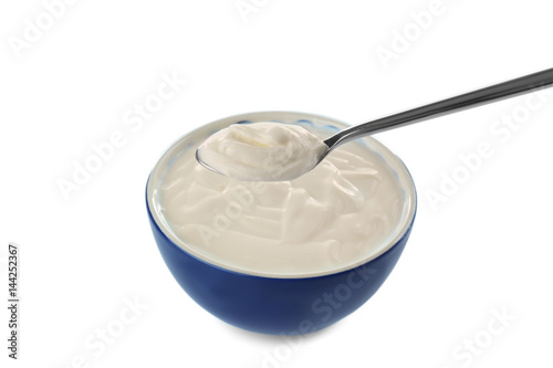 Tasty yogurt in bowl with spoon on white background